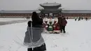 Pengunjung foto bersama saat salju turun di Istana Gyeongbok di Seoul, Korea Selatan (15/2). Istana Gyeongbok merupakan kerajaan utama selama Dinasti Joseon dan salah satu landmark terkenal di kota tersebut. (AFP Photo/Lee Jin-man)