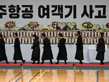 Para pelayat memberikan penghormatan di altar peringatan bagi para korban kecelakaan pesawat Jeju Air, di Muan Sports Park di Muan pada Senin 30 Desember 2024. (JUNG YEON-JE/AFP)