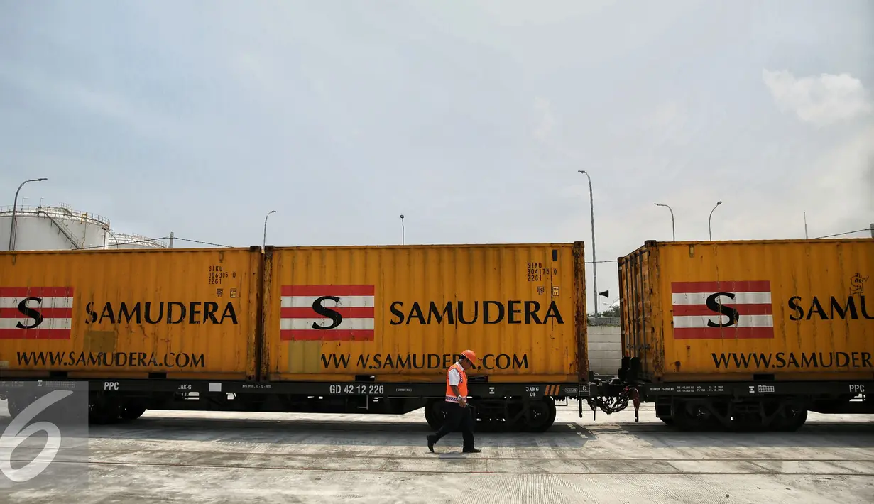 Petugas melintas di muatan KA Logistik di Stasiun JICT Tanjung Priok, Kamis (18/2/). Dioperasikannya KA Logistik Tanjung Priok diharapkan mampu menurunkan masalah waktu bongkar muat atau dwelling time hingga dua hari. (Liputan6.com/Faizal Fanani)