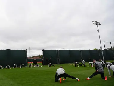 Para pemain Liverpool melakukan pemanasan saat menghadiri sesi pelatihan di kompleks pelatihan Melwood tim di Liverpool, Inggris barat laut, (23/4). Liverpool akan bertanding melawan wakil Italia, AS Roma di stadion Anfield. (AFP Photo/Paul Ellis)