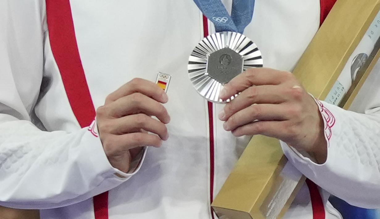 Pebulu tangkis tunggal putri China, He Bing Jiao memegang pin bergambar bendera Spanyol dan medali perak Olimpiade Paris 2024 setelah laga final yang berlangsung di Porte de la Chapelle Arena, Paris, Prancis, Senin (05/08/2024). (AP Photo/Kin Cheung)
