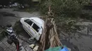 Sebuah mobil tertimpa pohon yang tumbang setelah hujan lebat akibat siklon Tauktae di Mumbai India, pada Selasa (18/5/2021). Topan Tauktae disebut yang terbesar melanda wilayah itu dalam beberapa dekade terakhir.  (AP Photo/Rafiq Maqbool)