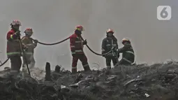 Petugas Pemadam Kebakaran Kabupaten Bogor memadamkan api di lapak ban bekas, Desa Bojong Nangka, Gunung Putri, Kamis (22/4/2021). Banyaknya bahan yang mudah terbakar dan sumber api yang berasal dari bawah tumpukan ban membuat  api di lokasi belum juga padam. (Liputan6.com/Herman Zakharia)