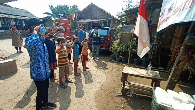 Warga Kampung Pemulung Hormat Bendera Merah Putih Dan Nyanyikan Lagu Indonesia Raya Untuk Dapatkan Nasi Bungkus Gratis. (Selasa, 17/08/2021). (Liputan6.com/Yandhi Deslatama).