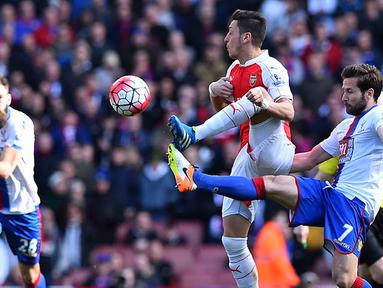 Gelandang Arsenal, Mesut Ozil, berebut bola dengan gelandang Crystal Palace, Yohan Cabaye, pada laga Liga Premier Inggris di Stadion Emirates, London, Minggu (17/4/2016). Kedua tim bermain imbang 1-1. (AFP/Ben Stansall)