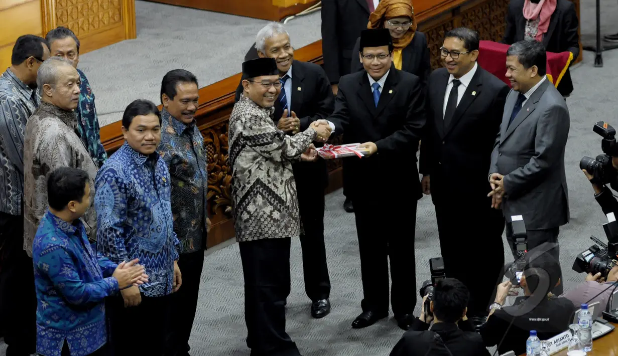 Ketua BPK RI Harry Azhar Azis (ketiga kiri) memberikan dokumen laporan kepada Wakil Ketua DPR Taufik Kurniawan (ketiga kanan) saat Rapat Paripurna dengan DPR RI di Komplek Parlemen, Jakarta, Selasa (7/4/2015). (Liputan6.com/Andrian M Tunay)