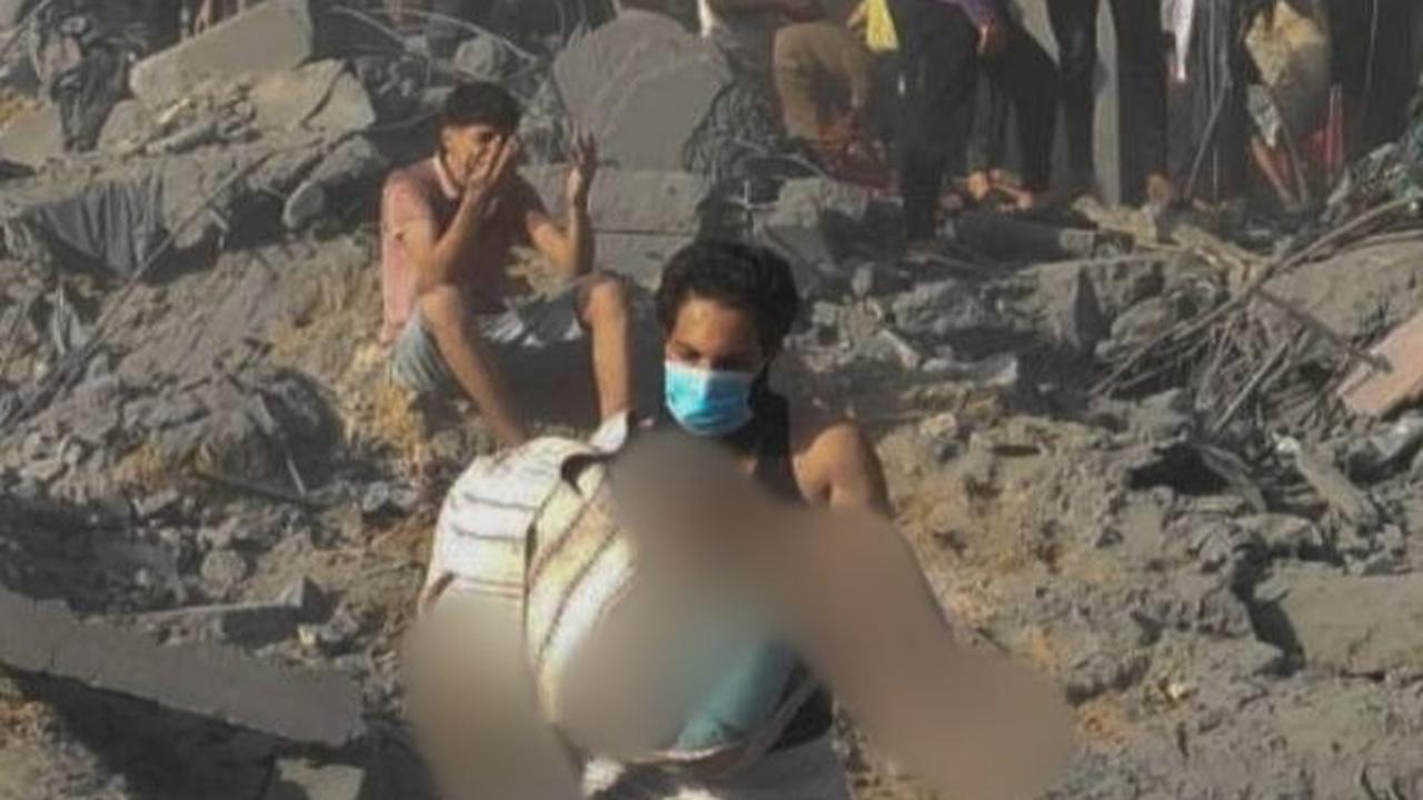 Seorang pria Palestina membawa jenazah kerabatnya di tengah proses evakuasi para korban usai serangan Isarel di kamp pengungsi Jabalia di Jalur Gaza utara.