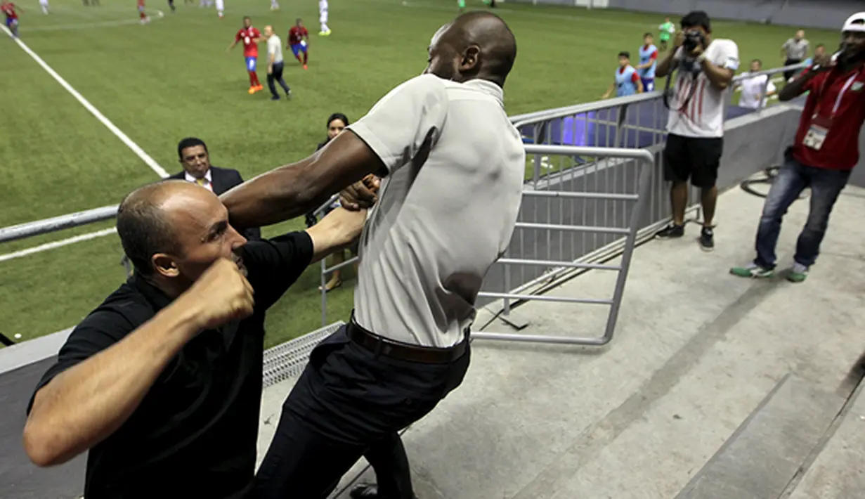 Pelatih tim sepakbola Costa Rica, Paulo Wanchope (kanan) berkelahi dengan petugas keamanan saat pertandingan melawan Panama pada kualifikasi Olimpiade di Maracana Stadium, Panama, Selasa (11/8/2015). (Reuters/Roberto Cisneros-La Prensa)