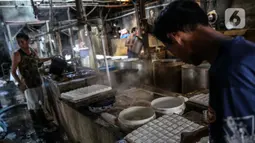 Pekerja beraktivitas di industri pembuatan tahu di Duren Tiga, Jakarta, Senin (3/8/2020). Pemerintah kembali meluncurkan program baru untuk membantu UMKM dalam melewati masa pandemi Covid-19, yaitu bantuan uang tunai dan kredit bunga rendah yang akan saling terintegrasi. (Liputan6.com/Faizal Fanani)