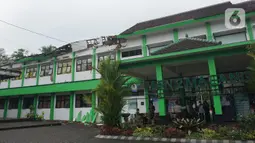 Sejumlah petugas berada di depan MAN 2 Malang yang rusak akibat gempa di Turen, Kabupaten Malang, Minggu (11/4/2021). Kejadian ini juga membuat 36 laptop, 25 PC, 20 set meja bahasa rusak. Sementara, seorang staf sekolah mengalami luka ringan setelah tertimpa genteng. (merdeka.com/Nanda F. Ibrahim)