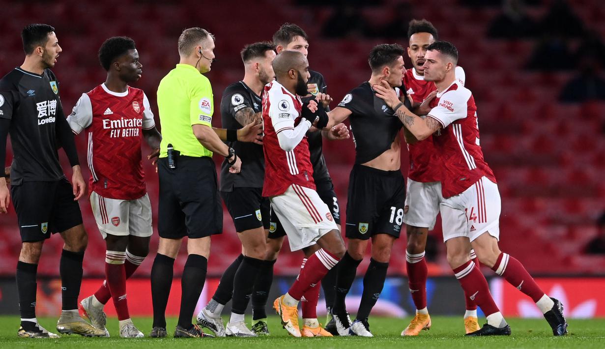 Gelandang Arsenal, Granit Xhaka, bersitegang dengan pemain Burnley, Ashley Westwood, pada laga Liga Inggris pada laga Liga Inggris di Stadion Emirates, Senin (14/12/2020). Arsenal takluk 0-1 dari Burnley. (Laurence Griffiths/Pool/AFP)
