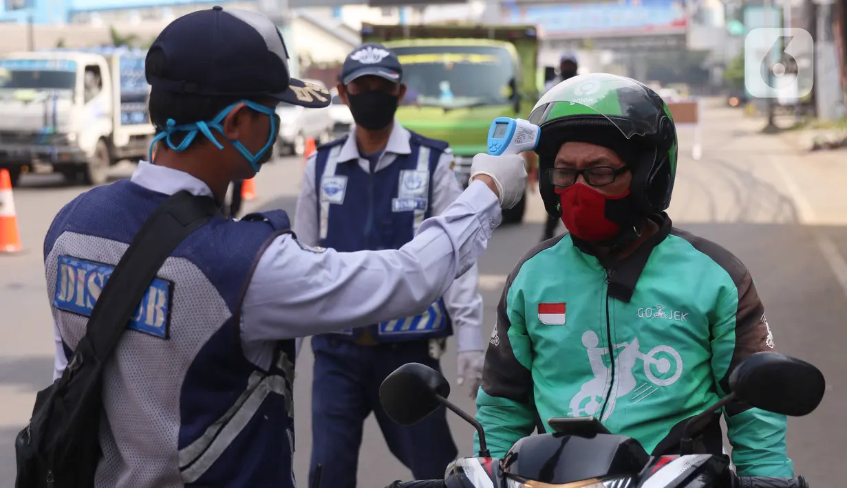 Petugas memeriksa suhu tubuh pengendara saat pelaksanaan Pembatasan Sosial Berskala Besar (PSBB) di kawasan Gading Serpong, Tangerang Selatan, Sabtu (18/4/2020). Pengukuran suhu tubuh tersebut merupakan cek point dari PSBB yang baru saja diberlakukan di Tangerang Raya. (Liputan6.com/Angga Yuniar)