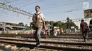 Seorang siswa menyeberangi perlintasan rel kereta api di kawasan Pisangan Baru, Jakarta, Selasa (10/9/2019). Mereka nekat menantang maut menyeberangi rel di dekat stasiun Jatinegara tersebut lantaran tidak adanya akses jembatan penyeberangan orang (JPO). (merdeka.com/Iqbal Nugroho)