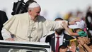 Paus Fransiskus memegang kepala seorang anak saat tiba untuk mengadakan misa di Stadion Zayed Sports City di Abu Dhabi, Uni Emirat Arab (5/2). Paus menggelar misa terbuka yang dihadiri 135 ribu jemaah di Zayed Sport City. (AP Photo/Kamran Jebreili)
