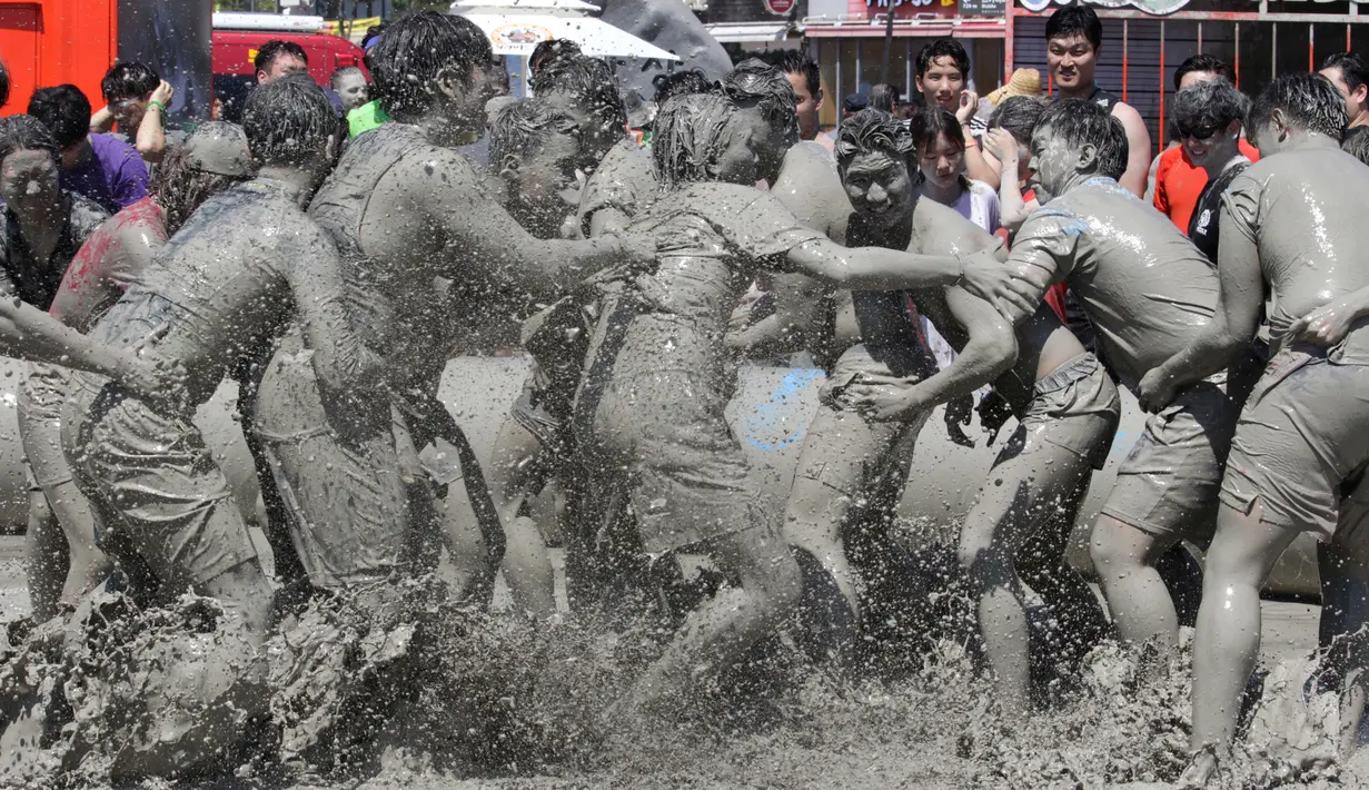 Sejumlah orang bermain di kolam lumpur selama Festival Lumpur Boryeong di Pantai Daecheon di Boryeong, Korea Selatan, (14/7). Festival lumpur tahunan ke-21 ini menampilkan gulat lumpur. (AP Photo / Ahn Young-joon)