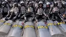 Masih memakai atribut lengkapnya, para polisi tampak asyik duduk dan beristirahat diatas aspal bersama rekan-rekannya, Jakarta, Kamis (21/8/14). (Liputan6.com/Miftahul Hayat)
