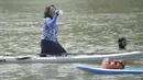 Menteri Kelautan dan Perikanan, Susi Pudjiastuti, melepas dahaga saat bermain paddle board di Danau Sunter, Jakarta, Minggu (25/2/2018). Kegiatan ini dilakukan dalam rangka Festival Danau Sunter. (Bola.com/Okie Prabhowo)