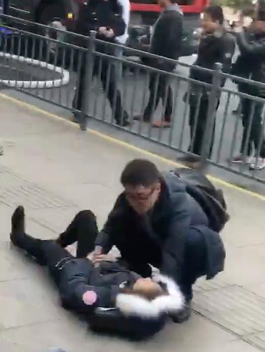 Seorang pria membantu pejalan kaki yang cedera ditabrak sebuah van di trotoar daerah sibuk di Shanghai, China, Jumat (2/2). Belum ada pernyataan dari kepolisian mengenai apakah insiden itu disengaja atau murni kecelakaan. (AP Photo)