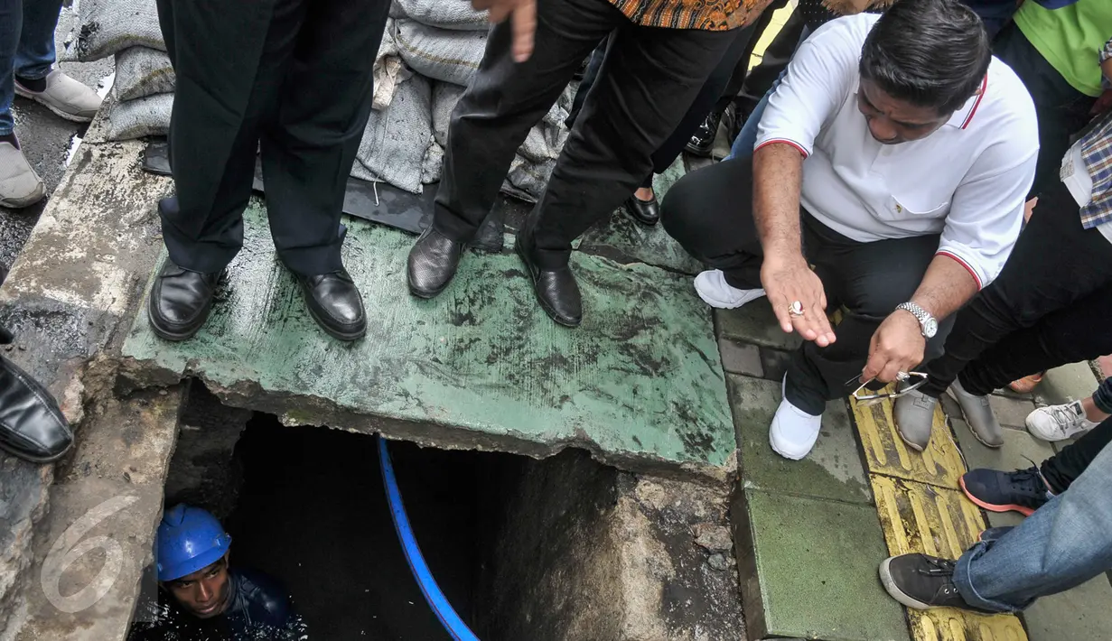 Plt gubernur DKI Jakarta Sumarsono (baju putih) melihat kerja Pasukan Biru di gorong-gorong Jalan Gatot Subroto, Jakarta Selatan, Jumat (10/3). Kawasan itu bagian dari lokasi ditemukan sampah kulit kabel di dalam gorong-gorong. (Liputan6.com/Yoppy Renato)