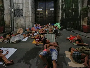 Sejumlah orang tidur di depan sebuah gereja di Manila, Selasa (18/10). Semenjak operasi narkoba Duterte digencarkan, banyak warga Filipina memilih tidur di jalan dan meninggalkan rumah mereka karena khawatir menjadi sasaran. (REUTERS/Damir Sagolj)