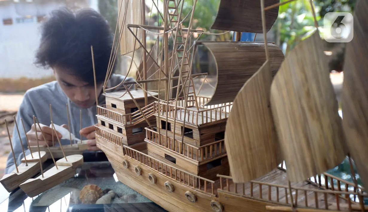 Perajin menyelesaikan pembuatan miniatur kapal pinisi yang terbuat dari limbah bambu di Pondok Benda, Pamulang, Tangerang Selatan, Senin (09/11/2020). Kerajinan berbahan bambu bekas yang dijual dengan harga berkisar Rp.50 ribu hingga Rp.250 ribu tergantung ukurannya. (merdeka.com/Dwi Narwoko)