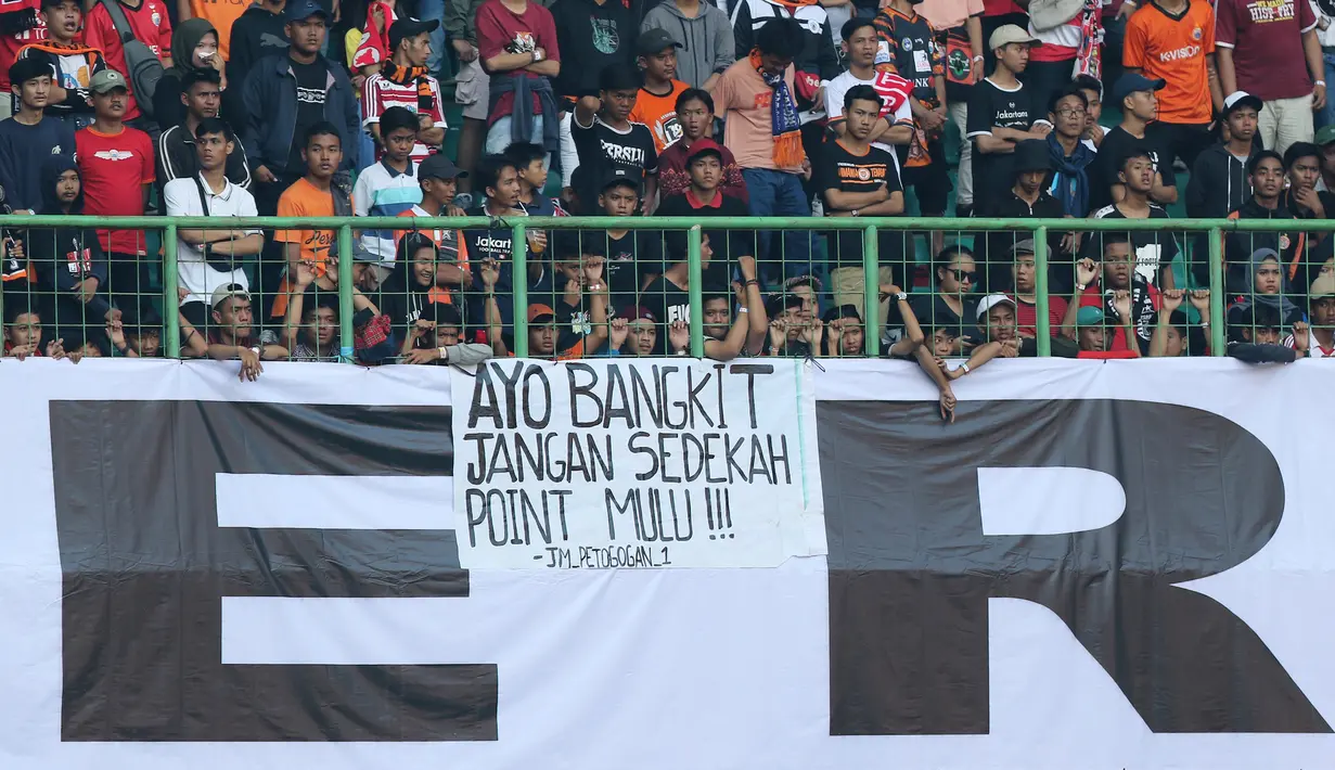 Suporter Persija Jakarta memasang spanduk protes saat pertandingan melawan Perseru Badak Lampung pada laga Liga 1 2019 di Stadion Patriot, Bekasi, Minggu (1/9). Persija takluk 0-1 dari Badak Lampung. (Bola.com/M Iqbal Ichsan)