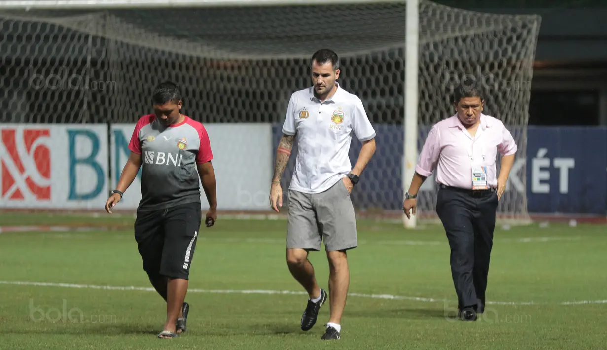 Pelatih Bhayangkara FC, Simon McMenemy (tengah) memantau lapangan saat hujan sebelum memulai sesi latihan di Stadion Patriot Bekasi, Sabtu (11/11/2017). Latihan tersebut jelang melawan Persija. (Bola.com/Nicklas Hanoatubun)
