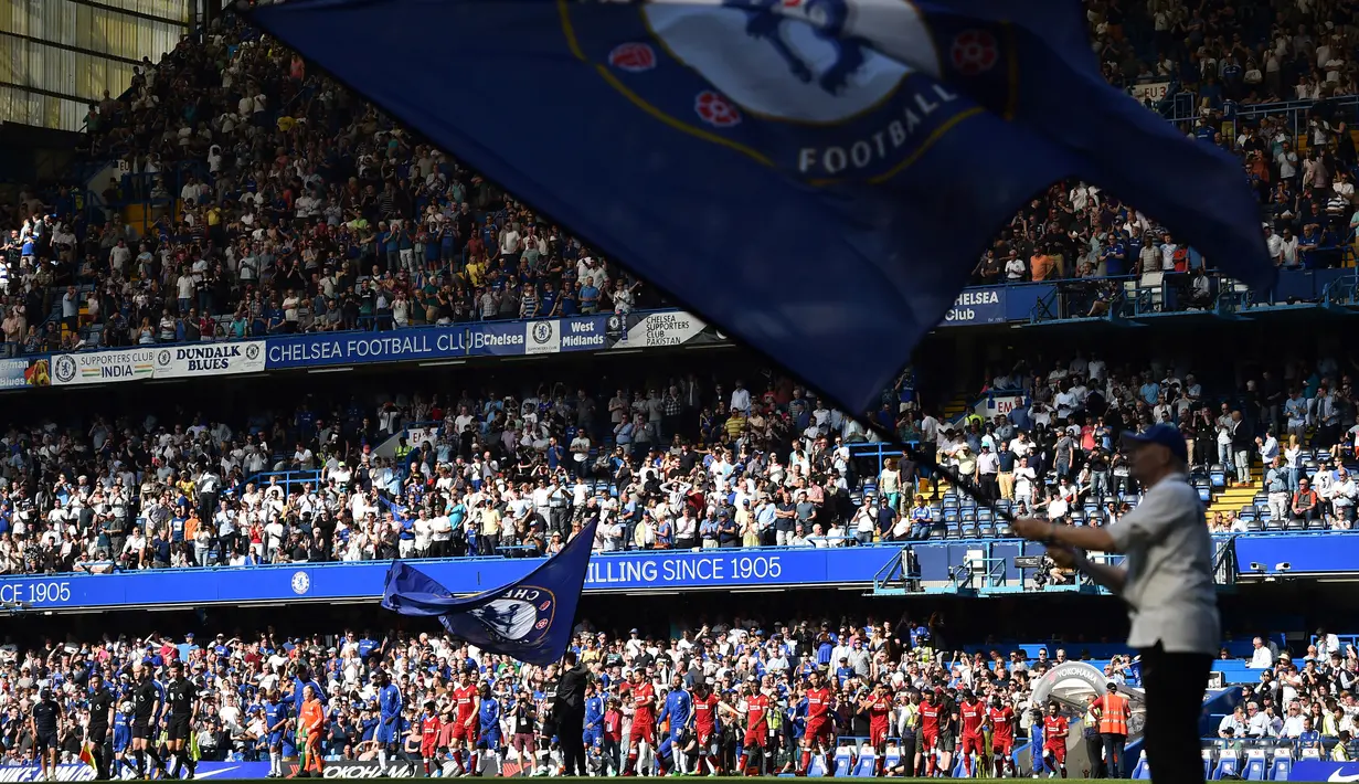 Para pemain Chelsea dan Liverpool masuk ke dalam lapangan untuk bertanding pada lanjutan Liga Inggris di Stamford Bridge di London (6/5). Chelsea menang tipis atas Liverpool 1-0 berkat gol Giroud. (AFP Photo/Glyn Kirk)