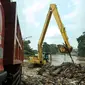 Alat berat dan truk mengangkut tumpukan sampah di pinggir kali Ciliwung Rawajati, Jakarta, Selasa (8/3/2016). Hujan yang mengguyur Bogor dua hari terakhir mengakibatkan banjir kiriman yang disertai sampah batang bambu. (Liputan6.com/Helmi Fithriansyah)