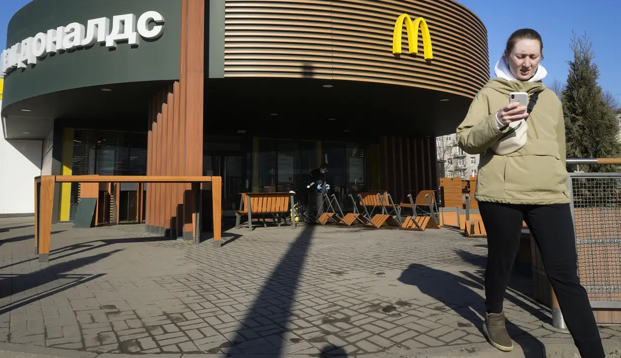 Seorang perempuan berjalan melewati restoran McDonald's yang tertutup untuk pengunjung di St. Petersburg, Rusia, Selasa (15/3/2022). Penutupan ini dilakukan pihak McDonald's sebagai sikap atas invasi Rusia ke Ukraina yang berlangsung dari 24 Februari 2022 lalu. (AP Photo)