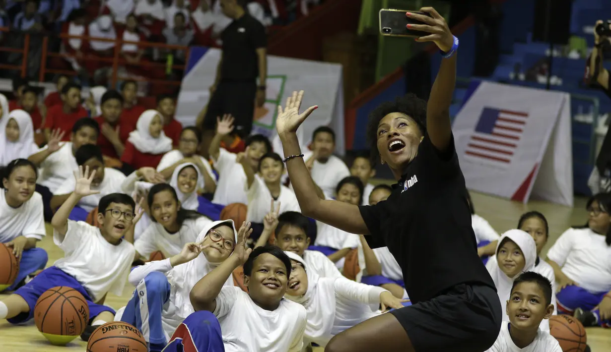 Sejumlah anak-anak berswafoto dengan instruktur saat mengikuti coaching clinic bersama Jr. NBA di GOR Soemantri Brodjonegoro, Kuningan, Jakarta, Kamis (17/10). Jr. NBA bekerjasama dengan Pemprovi DKI Jakarta padukan kurikulum olahraga basket dan pengembangan kebugaran. (Bola.com/Yoppy Renato)