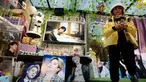 Seorang wanita melewati gambar anggota band K-Pop Korea Selatan BTS di sebuah kafe di Seoul, Korea Selatan, Senin (11/12/2023). (AP Photo/Ahn Young-joon)