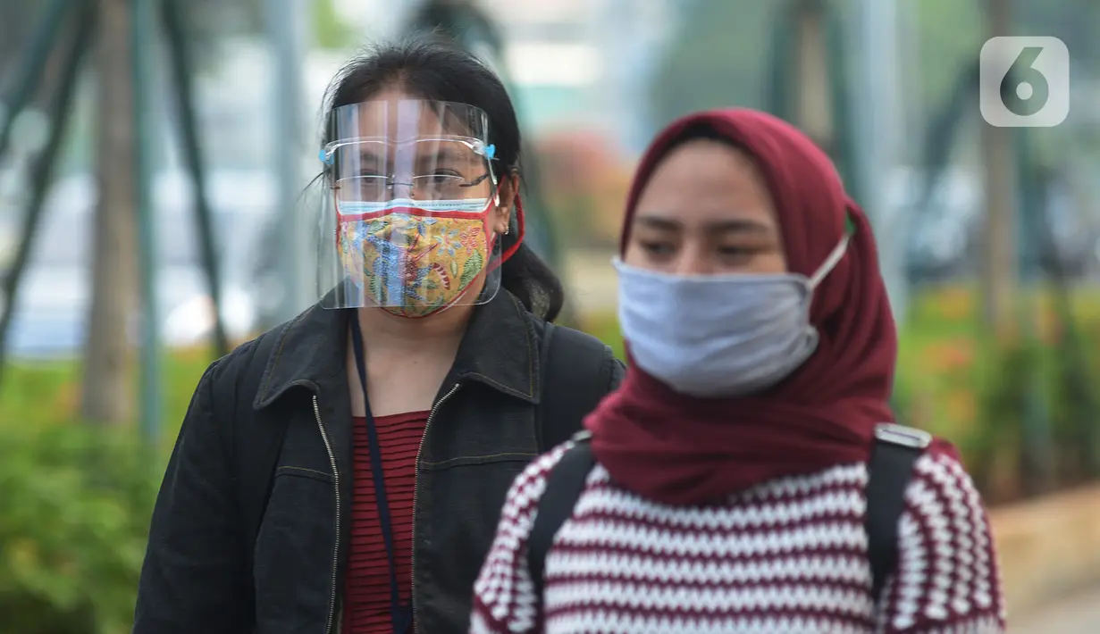 Seorang wanita yang mengenakan masker batik (kiri) berjalan di kawasan Thamrin Sudirman, Jakarta, Jumat (2/10/2020). Pada Hari Batik Nasional yang berlangsung di tengah pandemi COVID-19, sebagian masyarakat terlihat mengenakan baju dan masker dengan motif batik. (merdeka.com/Imam Buhori)
