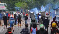 Dua kelompok warga terlibat tawuran di dekat Stasiun Manggarai, Jakarta Selatan, Minggu (8/1).  Puluhan orang terlihat membawa senjata tajam, bongkahan batu dan petasan. (Liputan6.com/Angga Yuniar)