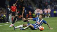 Pemain Barcelona, Lamine Yamal, menggiring bole melewati penjagaan bek Espanyol, Carlos Romero, dalam sebuah pertandingan Liga Spanyol yang digelar di RCDE Stadium, Jumat (16/5/2025) dini hari WIB. (AP Photo/Joan Monfort)