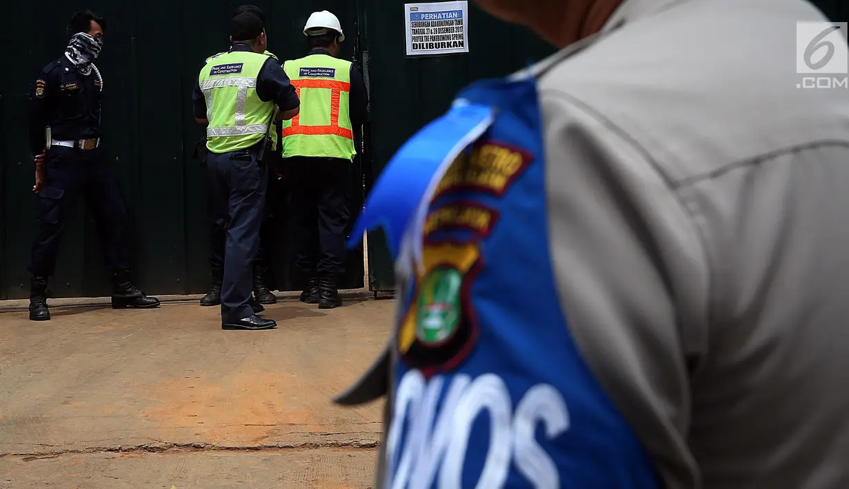 Petugas keamanan berjaga di lokasi ambruknya bangunan proyek Apartemen Pakubuwono Spring 3 di Jalan Teuku Cut Nyak Arief, Jakarta, Rabu (27/12). (Liputan6.com/JohanTallo)