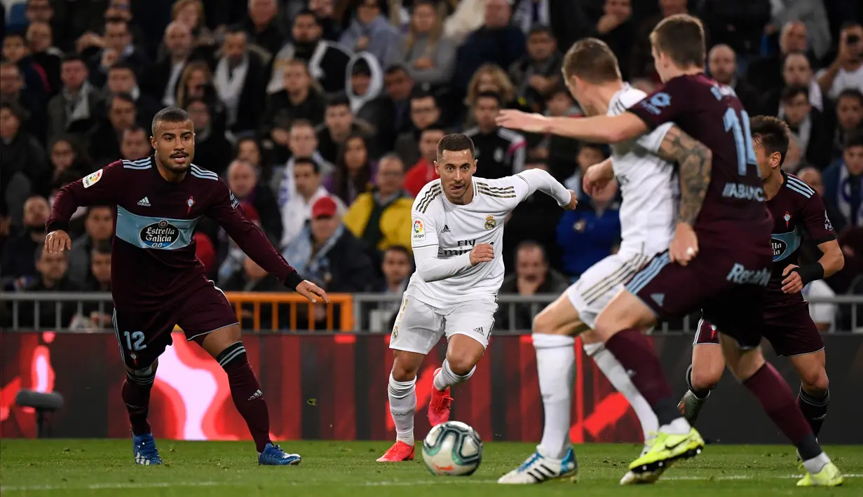 Gelandang Real Madrid, Eden Hazard (tengah) berlari mengejar bola saat bertanding melawan Celta Vigo pada pertandingan lanjutan La Liga Spanyol di stadion Santiago Bernabeu di Madrid, Spanyol, Minggu, (16/2/2020). Madrid bermain imbang 2-2 atas Celta Vigo.  (AFP/Pierre-Philippe Marcou)