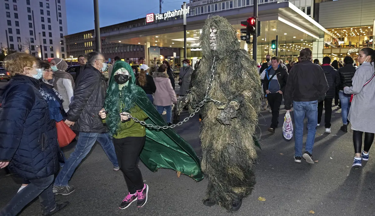 Orang-orang yang mengenakan kostum menakutkan tiba di stasiun kereta untuk Zombie Walk dan Parade Halloween tahunan di Essen, Jerman, Minggu (31/10/2021). Setiap 31 Oktober sebagian masyarakat dunia ikut memeriahkan perayaan Halloween. (AP Photo/Martin Meissner)
