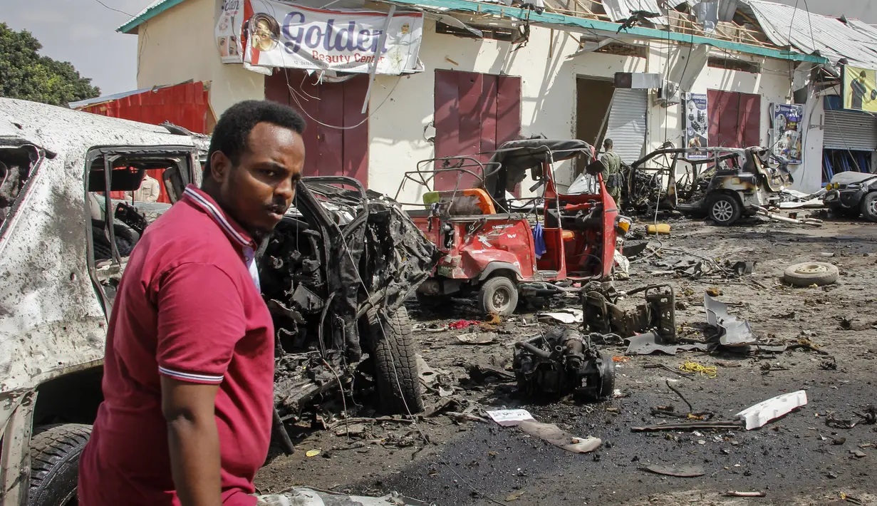Seorang pria berjalan melewati reruntuhan di lokasi pemboman di Mogadishu, Somalia (13/2/2021). Mobil yang membawa bom itu melaju melalui pos pemeriksaan di depan Hotel Wehliye yang cukup populer di kalangan pejabat setempat dan kelompok elite Somalia. (AP Photo/Farah Abdi Warsameh)