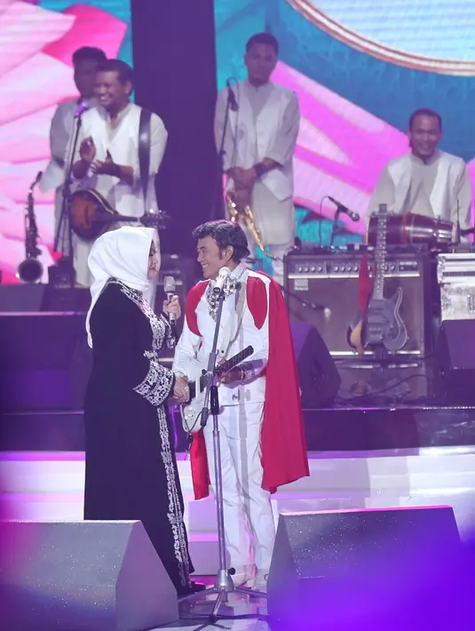Selain itu, Rhoma yang juga aktor itu berduet dengan istrinya Ricca Rahim. Rhoma mengaku kaget saat melihat istrinya duduk dibarisan penonton. Rhoma mendekati Ricca dan mengandengnya ke atas panggung. (Nurwahyunan/Bintang.com)