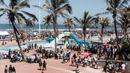 Ribuan wisatawan bersuka ria saat perayaan Tahun Baru di South Beach, Durban, Afrika Selatan, 1 Januari 2022. Menurut polisi Afrika Selatan, hampir 50 ribu orang diperkirakan akan menghabiskan hari di pantai. (Rajesh JANTILAL/AFP)