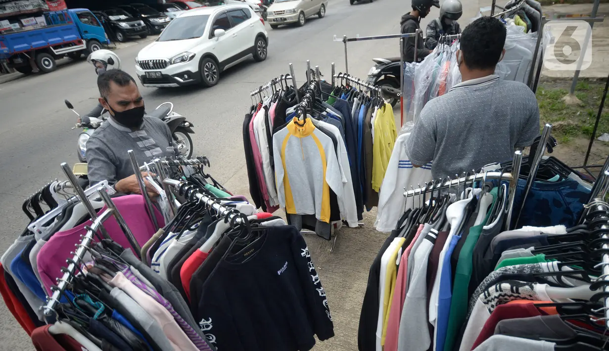 Ridwan (40) menata baju seken (baju bekas) impor di Pamulang, Tangerang Selatan, Banten, Senin (29/9/2020). Pada saat pandemi baju bekas impor masih diminati masyarakat karena murah harganya. (merdeka.com/Dwi Narwoko)