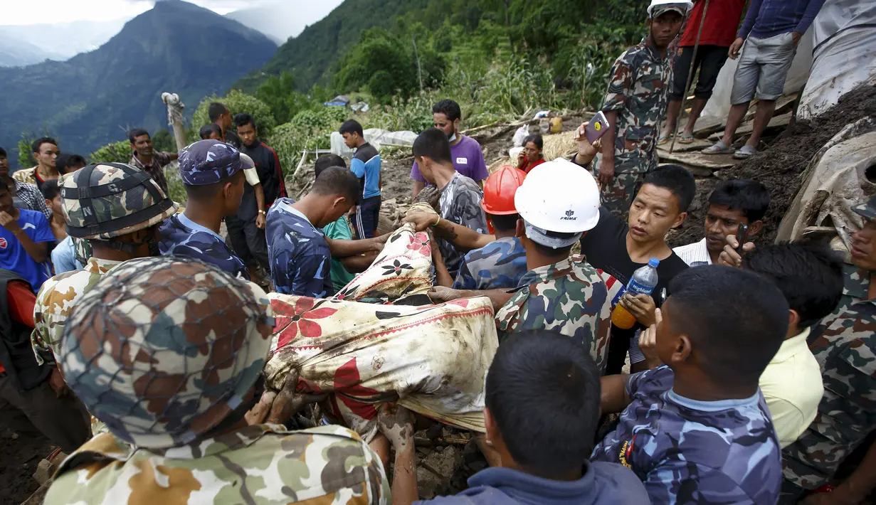 Petugas mengevakuasi tubuh korban tanah longsor di Desa Lumle, Nepal (30/7/2015). Tanah longsor yang dipicu hujan deras tersebut menewaskan sedikitnya 30 orang dan menghacurkan puluhan rumah. (REUTERS/Navesh Chitrakar)