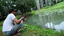 Seorang warga memanfaatkan area danau untuk memancing di Taman Langsat, Kebayoran Baru, Jakarta Selatan, Kamis (06/03/14). (Liputan6.com : Andrian Martinus Tunay)
