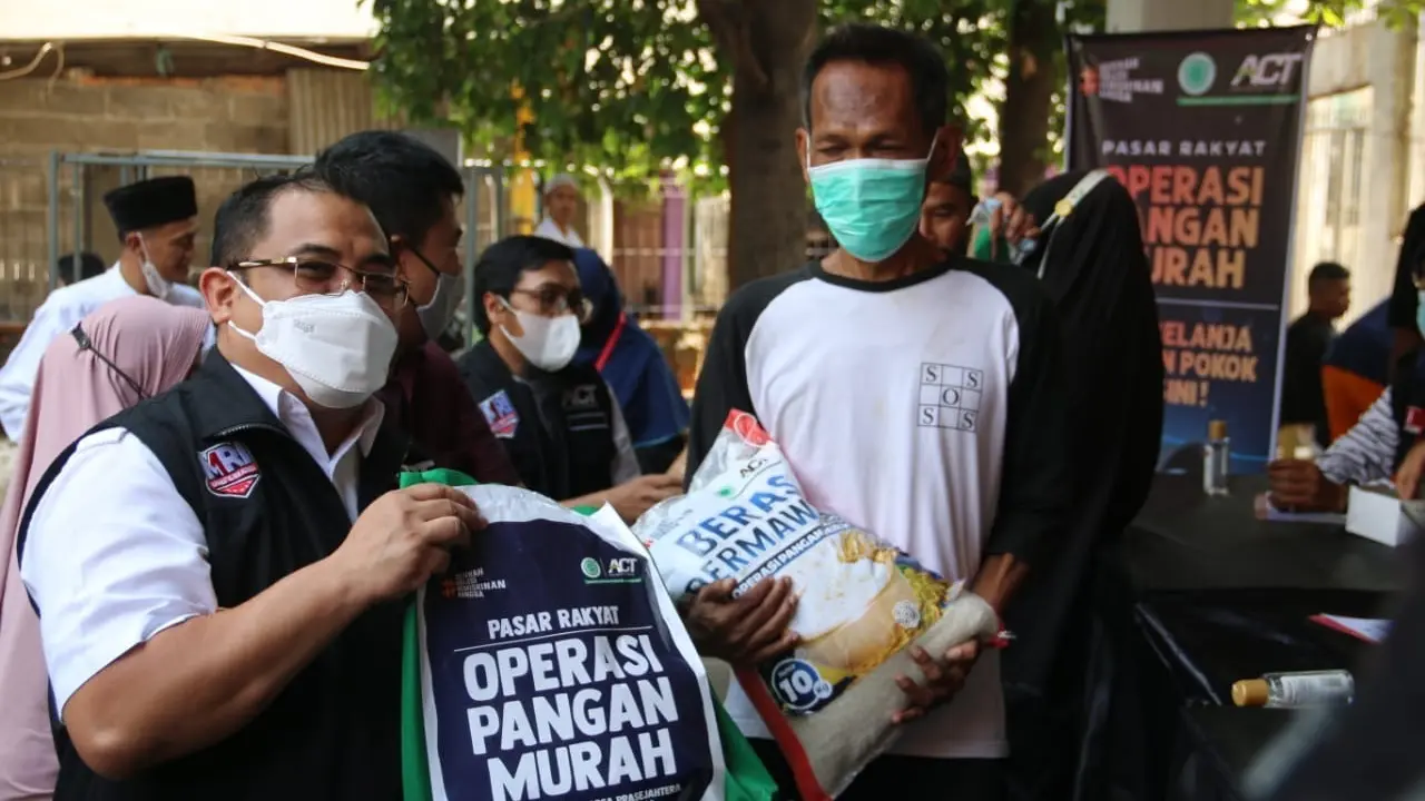 Presiden ACT Ibnu Khajar (kiri) saat memberikan paket sembako dalam Operasi Pangan Murah di Masjid Assuada, Kecamatan Koja, Jakarta Utara, Jumat (15/10/2021).