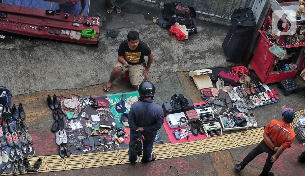 Pedagang menggelar lapak di pinggir jalan di Pasar Loak Lebayoran Lama, Jakarta, Jumat (9/9/2022). Masyarakat banyak memburu barang dagangan yang dijual mulai dari pakaian, tas, aksesori hingga elektronik. (Liputan6.com/Angga Yuniar)