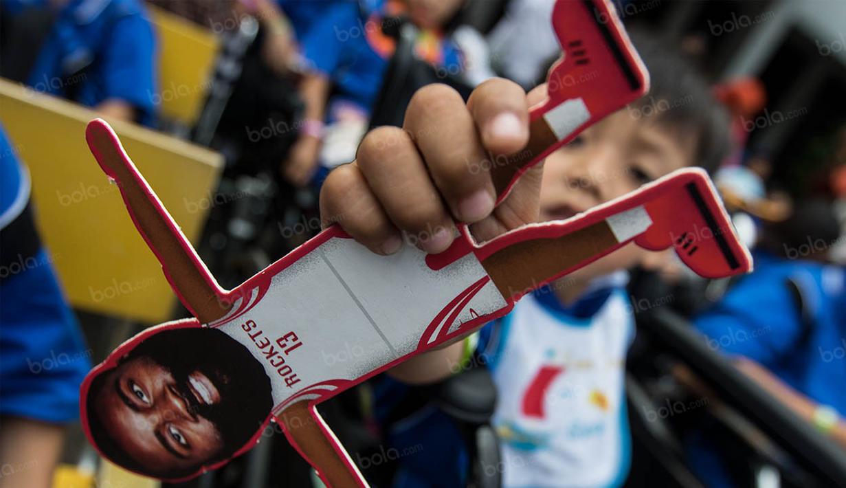 Seorang anak penyandang disabilitas menunjukan miniatur  pebasket NBA dari klub Houston Rockets, James Harden. (Bola.com/Vitalis Yogi Trisna)