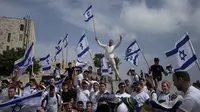 Warga Israel mengibarkan bendera nasional selama pawai&nbsp;peringatan&nbsp;Hari Yerusalem di luar Kota Tua Yerusalem pada Kamis (18/5/2023). (Dok. AP/Maya Alleruzzo)
