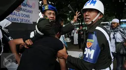 Seorang pria yang diduga provokator dalam aksi damai 2 Desember ditangkap oleh polisi Militer Angkatan Laut di kawasan Monas, Jakarta, Jumat (2/12). Pria itu tertangkap tangan membawa golok saat aksi damai tengah berlangsung. (Liputan6.com/Gempur M Surya)