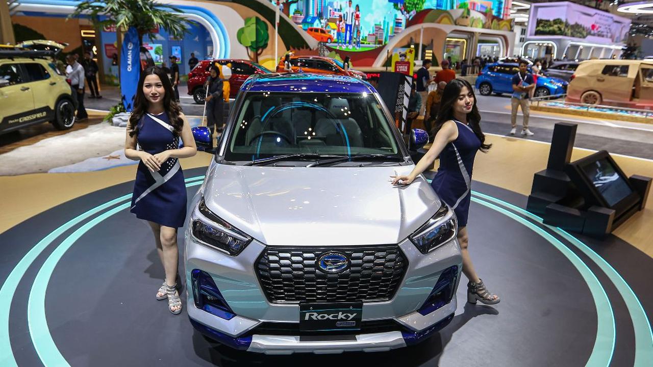 Sales Promotion Girl (SPG) berpose di sebelah Rocky e-Smart Hybrid versi Japan Domestic Market (JDM) pada booth Daihatsu selama pameran Gaikindo Indonesia International Auto Show (GIIAS) 2024 di Indonesia Convention Exhibition (ICE) BSD, Kabupaten Tangera